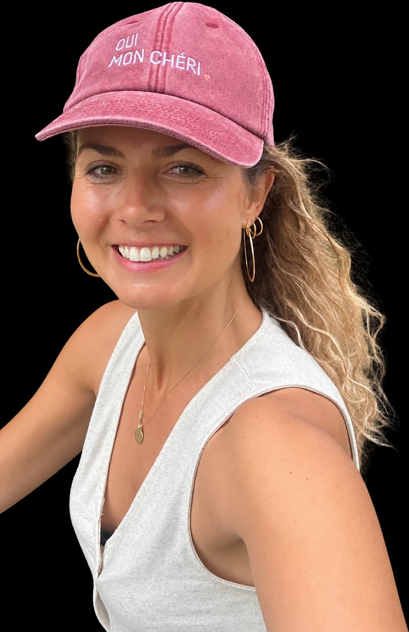Julia Barth im Freien, lachend, mit rosafarbener Cap — freigestellt